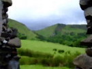 Antrim Countryside (Green hills viewed through gap in stone wall)
